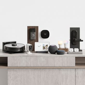 Home gadgets and accessories including a robot vacuum, security camera, smart display, speakers, lights, and plugs